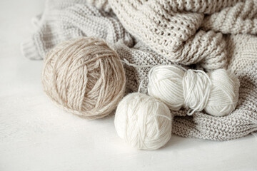 Close-up of yarn in pastel colors and knitted cozy sweaters.