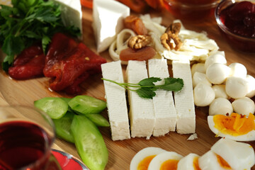 Delicious traditional turkish breakfast on yellow checkered tablecloth.
Tea, olives, eggs, cheeses, cucumbers, tomatoes,salami