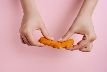 Woman holding a broken cheese stick, close