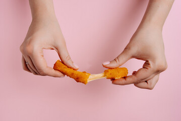 Obraz premium Woman holding a broken cheese stick, close