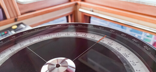 Compass aboard large ship on a blue summer sea ocean day