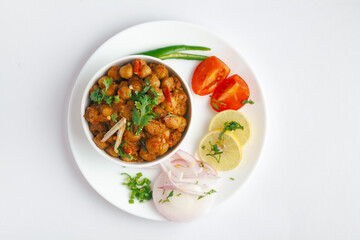 Chickpeas masala (Spicy chola or chhole curry)  garnished with fresh green coriander and ingredients. Served in a ceramic bowl. An Classic Indian typical Panjabi street food.  