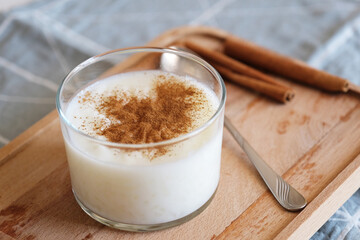 Sutlac, Rice pudding with cinnamon in glass bowl on wooden stand