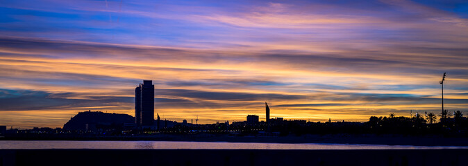 skyline de barcelona al atardecer con luces amarillas 
