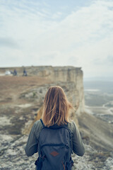 Woman stay on a rock, looking at the landscape and enjoying the view and fresh air.