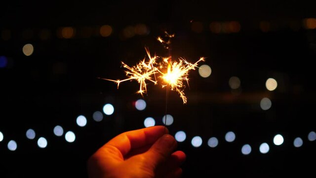 sparklers, sparkler at night on a dark background christmas lights