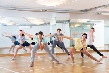Obraz na płótnie Canvas Active teens learn new dance moves in dance studio