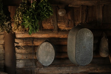 Still life, bath accessories on a wooden log wall. Natural flowers. A basin, a metal trough, brooms for the bath. Village, canopy, barn.