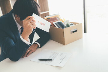 Sad dismissed businessman sitting outside the office after losing his job