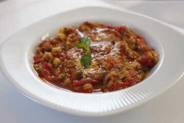 Eggplant and capia pepper mix appetizer on a white plate. Turkish food. Close up