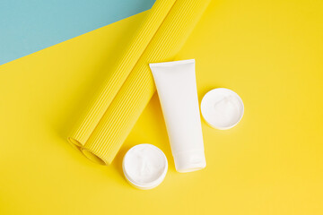 A set of cosmetics in various white packaging on a modern abstract yellow background. Health beauty spa treatments