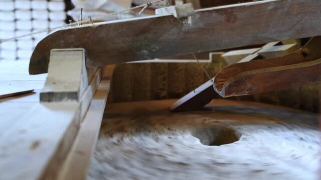The ancient old stone grain mill gristmill grinding wheat or grains into flour using millstone quern stone in the serbian house
