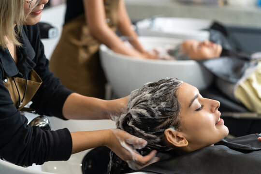 Caucasian female customer getting hair wash service in beauty salon.