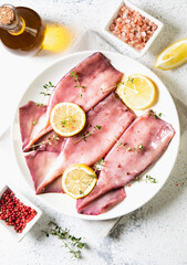 fresh squids octopus or cuttlefish for cooked food. Fresh raw cuttlefish. Raw squid with lemon. Top view and copy space for your text.