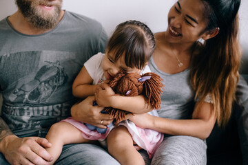 The family spends time at home. A child hugs a doll