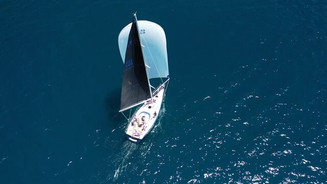 Aerial drone video of beautiful sail boat sailing in deep blue Aegean sea