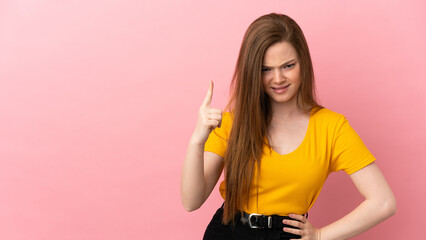 Teenager girl over isolated pink background frustrated and pointing to the front