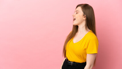 Teenager girl over isolated pink background laughing in lateral position