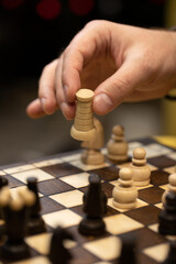 Hand taking his next step on game top view on chessboard. Human hand moving wooden white rook piece on Chess board selective focus close up. unexpected winning business solution concept