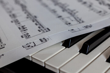 close up of piano keys with public domain music score resting on top