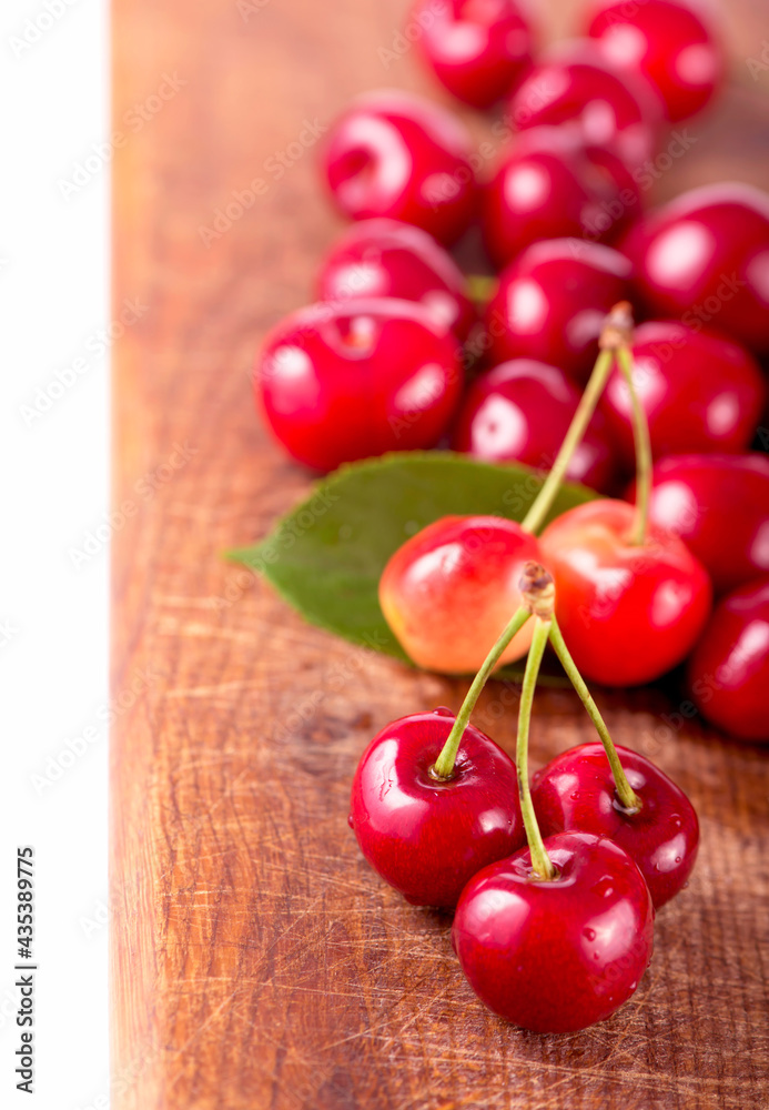 Wall mural Cherries on wooden table with water drops