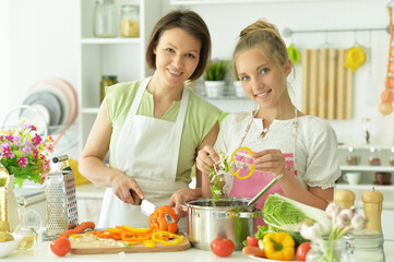 Cute little girl with mother cooking