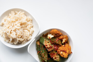 Okra, Hähnchen scharf mit Knoblauch und Chilli, Naturreis in Schale, Hintergrund weiß