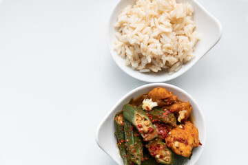 Okra, Hähnchen scharf mit Knoblauch und Chilli, Naturreis in Schale, Hintergrund weiß