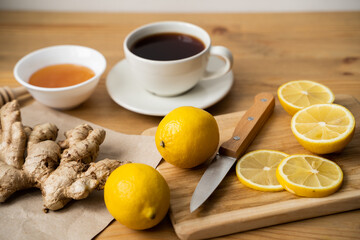 Tea, honey, lemon and ginger on a wooden table. The concept of traditional treatment for colds and flu