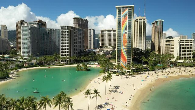 Cinematic 4K aerial trucking drone footage of high-rise hotels on the shore of Waikiki, vibrant, popular tourist destination near Honolulu on Oahu island in Hawaii known for its popular surf beach