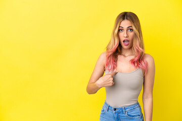 Young woman over isolated yellow background pointing to oneself