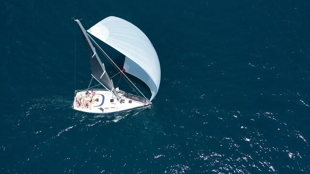 Aerial drone video of beautiful sail boat sailing in deep blue Aegean sea