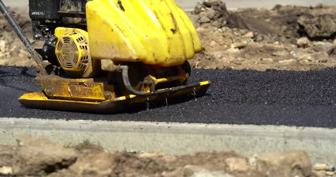 Road construction process. Workers are making a roadway from bitum. Asphalt repair.