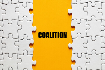 The word coalition between the jigsaw puzzle pieces. Alliance, cooperation and collaboration in...