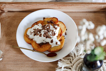 Pancakes with peaches, blueberries and banana in a cozy setting 