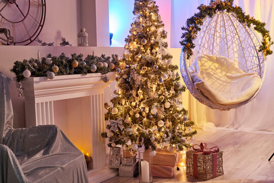 A white hanging wicker chair and a Christmas tree in the photo studio room. Location and background for the photo shoot