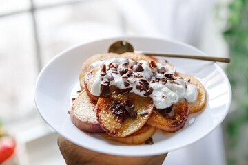 Pancakes with peaches, blueberries and banana in a cozy setting 