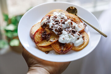 Pancakes with peaches, blueberries and banana in a cozy setting 