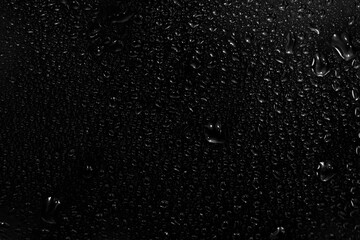 water drops on black background. abstract dew water droplets on a window glass for photo overlay...