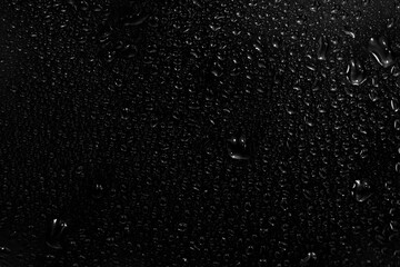 water drops on black background. abstract dew water droplets on a window glass for photo overlay...