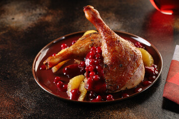 Roasted duck legs with red cranberry sauce and orange wedges. Delicious and healthy food.
