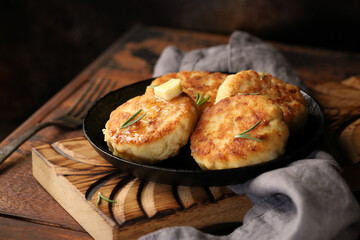 Fish cutlets (meatballs), in a cast-iron pan, with a slice of butter, decorated with rosemary leaves. Natural, homemade food.