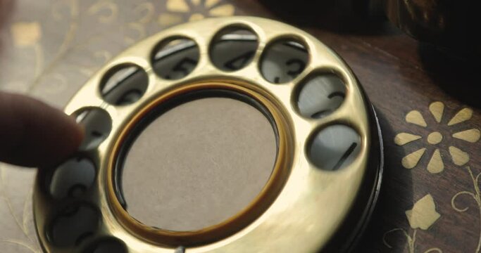Close-up view on an old style telephone dial. Rotating numbers by finger.
