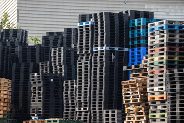 industry plastic and wooden pallets in factory yard background. shipping plastic pallet stacked at factory warehouse. Cargo and shipping concept.