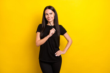 Photo of adorable lady hand hold pencil touch chin look empty space thinking isolated on yellow color background