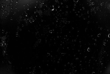 water drops on black background. abstract dew water droplets on a window glass for photo overlay effect or giving fresh effect on beverages mockup.