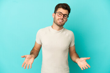 Young caucasian handsome man isolated on blue background happy and smiling