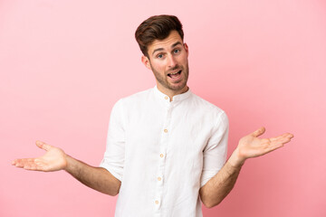 Young caucasian handsome man isolated on pink background with shocked facial expression