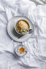 Dalgona coffee with apple oatmeal breakfast on white cozy bed