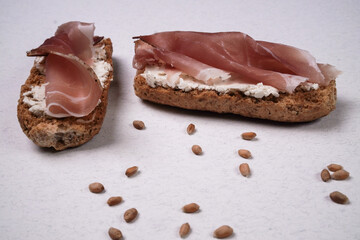 Tartina con prosciutto e semi di grano sul tavolo
